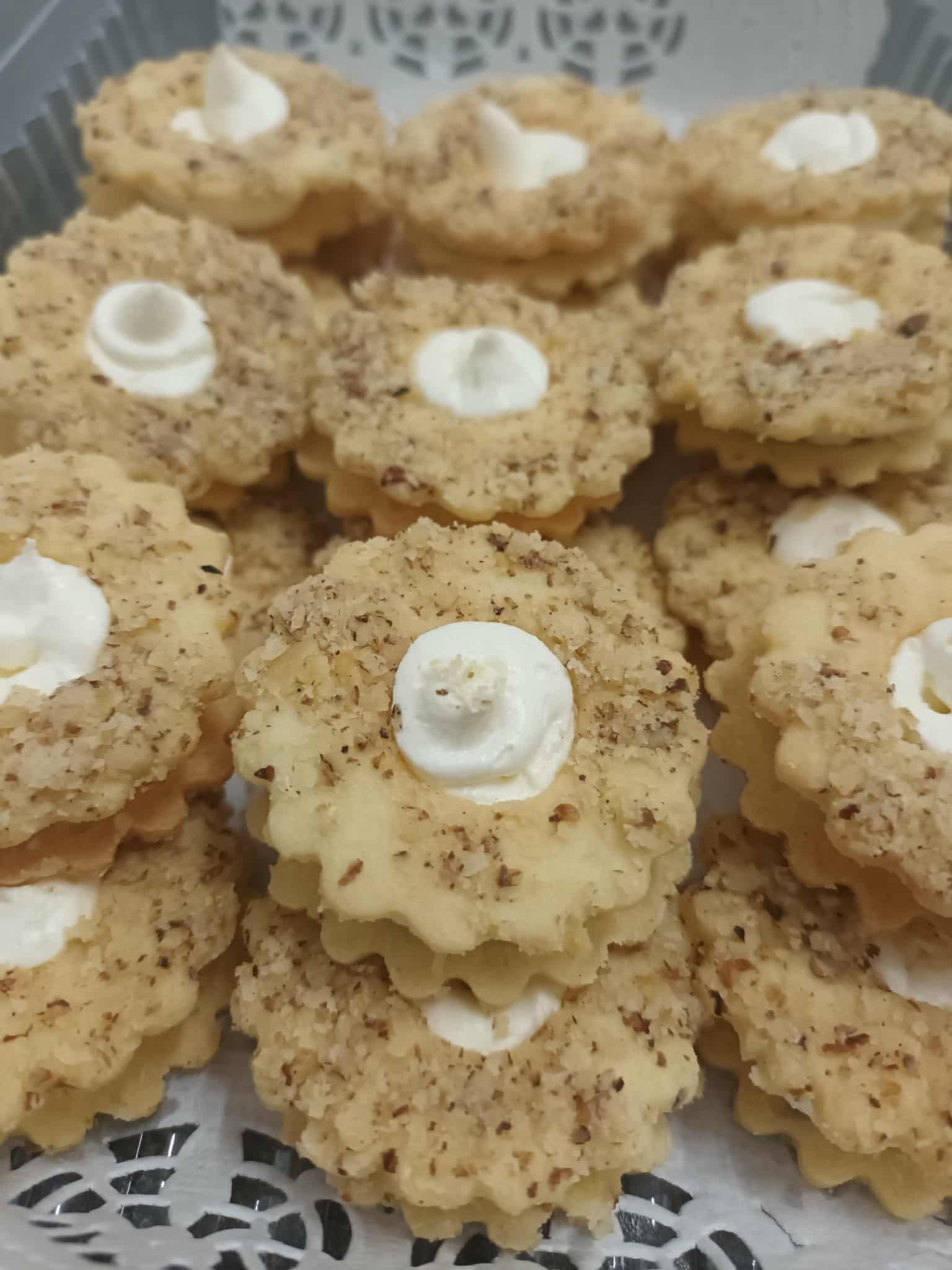 Walnuss-Linzeraugen – Gefüllt mit weißer Schokolade-Vanillecreme und mit Walnussdecke.